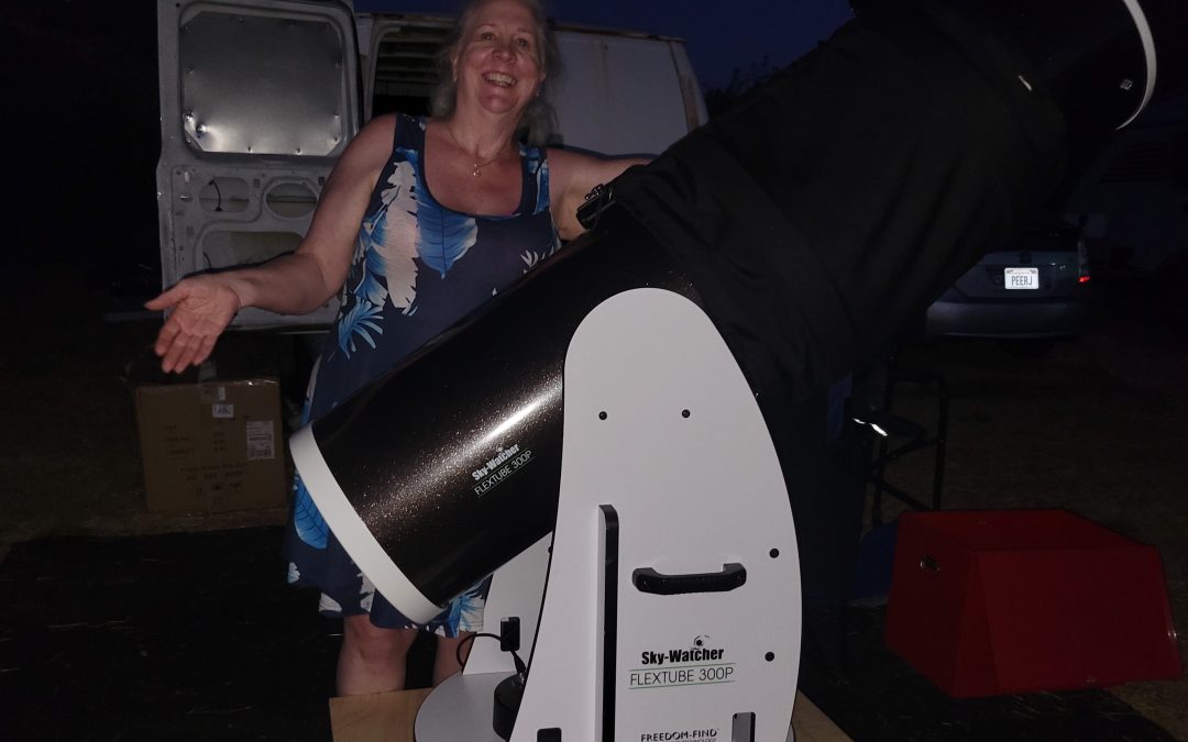 Sandy Eulitt doing her best Price is Right hostess imitation with her SkyWatcher 300P 12 inch Flextube Collapsible Dobsonian telescope